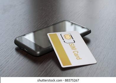 SIM Card And Mobile Phone On Table