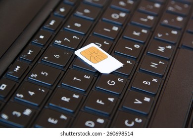 SIM card on laptop keyboard represents mobile internet.