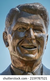 Simi Valley, California, USA - April 27, 2022: Ronald Reagan Presidential Library. Facial Portrait With Tie Of Lifesize Bronze Statue At Entrance To His Library Against Blue Sky.