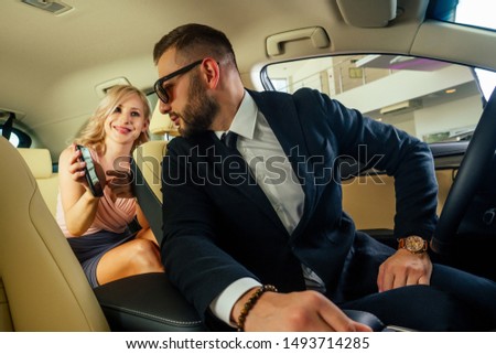 Similing driver talking with female passenger.