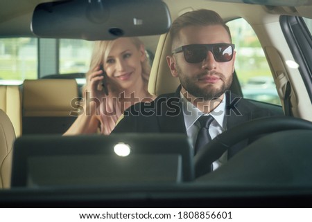 Similing driver talking with female passenger