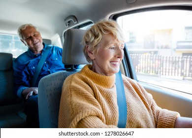 Similing senior female driver talking with male passenger. Close up of woman's face.
