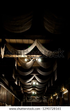 Simle but pompous. Ceiling drapery. Decorative old ceiling with drapes. Vintage or retro interior room design. Wood beam ceiling with draped textile. Classic overhead interior surface.