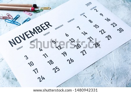 Simple 2019 November monthly calendar on table with office supplies