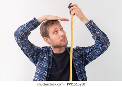 simple adult teenager male person with a roll tape measure the height against the wall - Shutterstock ID 1931515238