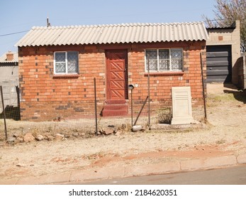 Simple Architecture Of Small Home On Dusty Street In Johannesburg South Africa.