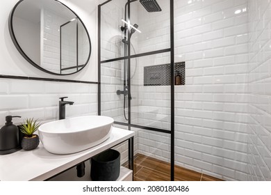 Simple bathroom with black shower, round mirror and classic white tiles - Shutterstock ID 2080180486