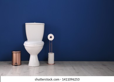 Simple bathroom interior with new toilet bowl near color wall. Space for text