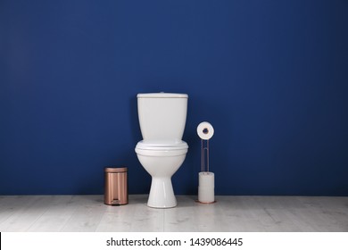 Simple bathroom interior with new toilet bowl near color wall