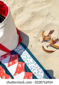 Simple beach scene with beach bag, blanket, and sandy sandals at Footbridge Beach in Ogunquit, ME. Taken in June 2021