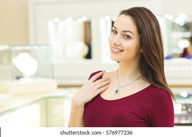 Simple Beauty. Stunning Young Brunette Woman Smiling Trying On A Diamond Necklace At The Jewelry Store Copyspace Luxury Happiness People Lifestyle Buying Customer Client Shopping Consumerism Concept