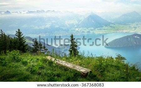 Simple bench on the edge of dropdown with view on the swiss mountains, lake and valley