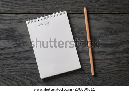 simple blank notepad with phrase wish list on rustic wood table, background