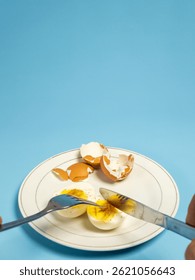 Simple breakfast with boiled eggs with pepper and soy sauce. Isolated on light blue background