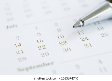 Simple calendar with days and months, focus on dates and pen. Closeup numbers shown mix color dot prints. Business meeting appointment, work planning management and vision concepts. Minimal style.
