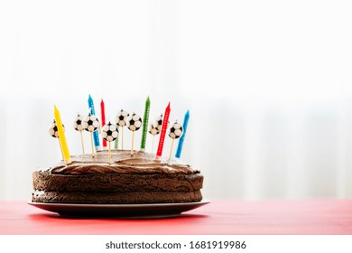 Simple Chocolate Cake With Chocolate Frosting And Colorful Candles Shaped As Soccer Balls. Football Theme Für Kids Birthday Party.