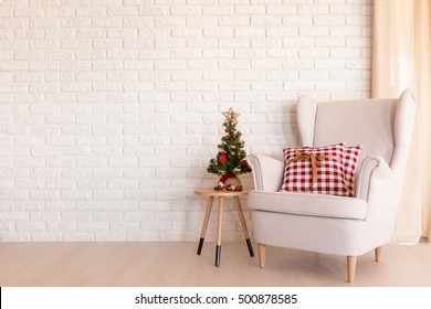 Simple Christmas living room with armchair and small Christmas tree
