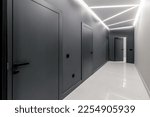 Simple clean newly built generic modern new real estate block of flats interior, long black corridor with black doors, perspective. New bought apartment, new home, hallway abstract concept