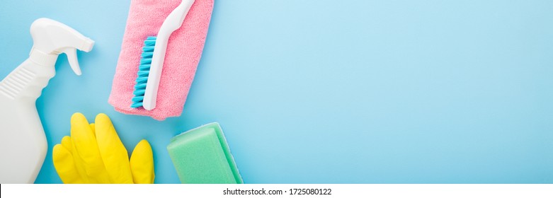 Simple Cleaning Set For Different Surfaces In Kitchen, Bathroom And Other Rooms. Spring Regular Cleanup. Light Pastel Blue Background. Closeup. Top View.  Wide Banner. Empty Place For Text Or Logo.