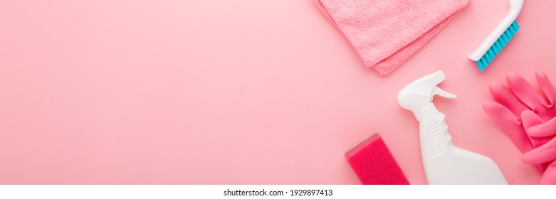 Simple cleaning set for different surfaces in kitchen, bathroom or other rooms. Spring regular cleanup. Light pastel pink background. Closeup. Top down view. Wide banner. Empty place for text or logo. - Powered by Shutterstock