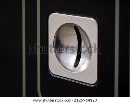 Simple coin insert slot, coin input hole panel object detail macro, extreme closeup, nobody. Payment, money, physical currency abstract concept. Business and finance, video game arcade, ticket machine