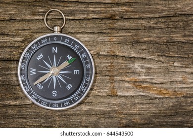 Simple compass on the wooden table with copy space - Shutterstock ID 644543500
