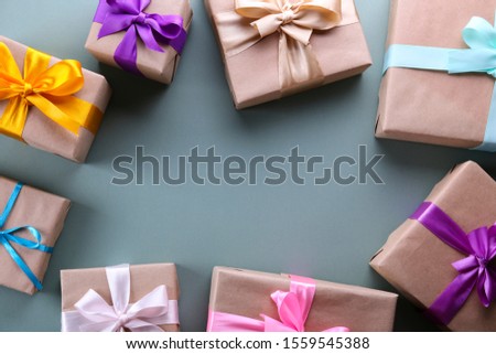 Simple composition with multiple presents wrapped in hand made blank craft paper gift wrap, pastel satin bow. Simple giftbox, wrapping, giftwrap, silk ribbon. Pink background, close up, copy space.