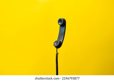 simple dark old telephone handset with cable. on pastel background