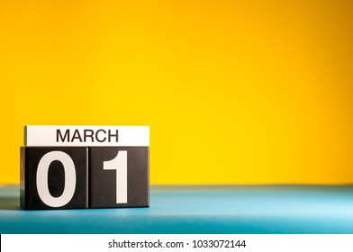 Simple desk calendar for March 1st. Day 1 of march month, calendar on blue and yellow background flat lay, top view. Spring time. Empty space for text
