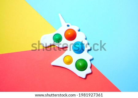 Simple dimple in form unicorn on colorful yellow, red and blue background.