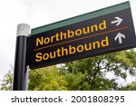 Simple directional sign pointing train passengers to northbound and southbound platforms at suburban commuter rail station