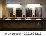 Simple efficiency of clean tiled modern interior public washroom with multiple sinks, faucets, soap dispensers and mirrors