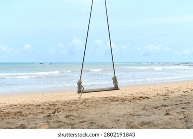 Simple and elegant composition featuring a beach swing framed by open ocean and clear skies. Great for travel advertising, inspirational messaging, mental wellness campaigns and vacation branding.