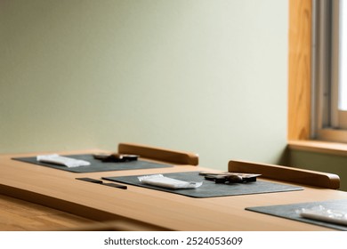 Simple and elegant Japanese restaurant table setup featuring placemats, utensils, and napkins in a serene, minimalistic dining environment - Powered by Shutterstock