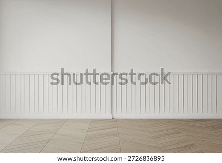A simple and elegant room featuring white wainscoting along the lower half of the wall and a wooden herringbone-patterned floor.