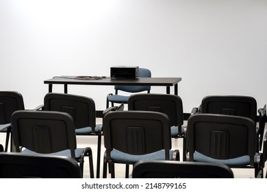 Simple Empty Prepared Lecture Hall, Conference Room Chairs And Presenter's Desk With A Video Projector, White Screen, Nobody, No People. Vacant Class Study Hall Concept, Low Attendance, Preparations