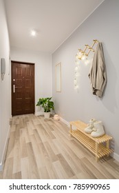 Simple entryway with wooden floor panels and shoe bench