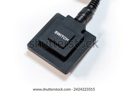 Simple generic black push button switch with the word SWITCH printed on top, object white background, cut out, nobody. Turning devices on and off, electronics control abstract concept, technology