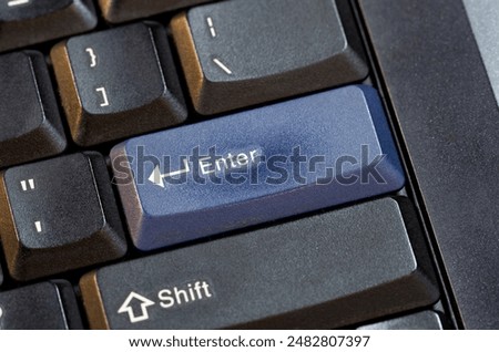 Simple generic wide ANSI layout blue enter key on a modern laptop computer keyboard, object closeup high angle, nobody, no people. Confirmation, data entry, accepting an action abstract concept