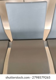 Simple grey plastic chair with solid seat and backrest arranged in row. Public furniture concept
