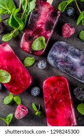 Simple and healthy summer dessert. Homemade berry ice cream popsicles with mint. Mojito lollypops, frosen diet infused water with blackberry, blueberry and raspberry. 