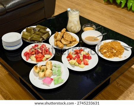 Simple home iftar table with assorted takjil, fried snacks, fresh fruits, and traditional cakes during Ramadan. Karet, Indonesia - February 27, 2026