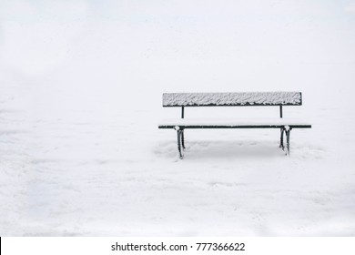 Simple Image Of A Park Bench In The Snow.