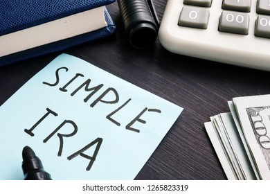 Simple Ira. Calculator, Money And Note Pad On A Table.