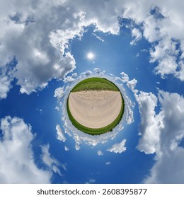 simple little tiny planet without buildings in blue sky with sun and beautiful clouds. Transformation of spherical panorama 360 degrees. Spherical abstract aerial view. Curvature of space.