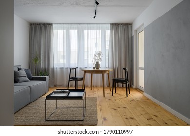 Simple Living Room With Exposed, Bare Concrete On Wall And Ceiling And Pine Wood Floor