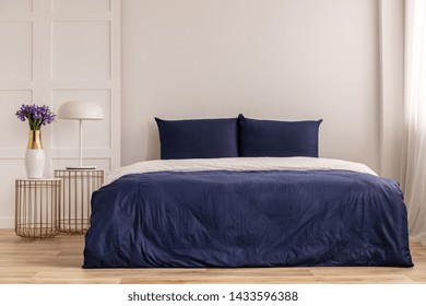 Simple Navy Blue And White Bedroom Interior With Cozy Bed With Pillows And Duvet