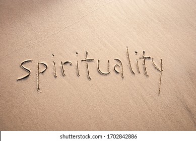 Simple non-demonitational spirituality message handwritten in lowercase letters on textured sand beach