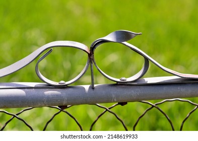 Simple ornament on a metal gate, with curved lines.