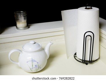 A Simple Paper Towel Holder, Holding A White Paper Towel Roll On A Kitchen Counter.